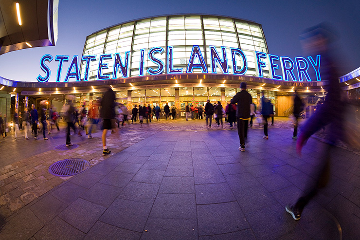 People walk towards the Staten Island Ferry terminal in the evening