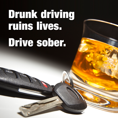 Car keys rest on a table next to a cocktail. Text overlay reads: Drunk driving ruins lives. Drive sober.