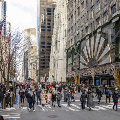 Multiple people walk along Fifth Avenue while it is closed to vehicular traffic.