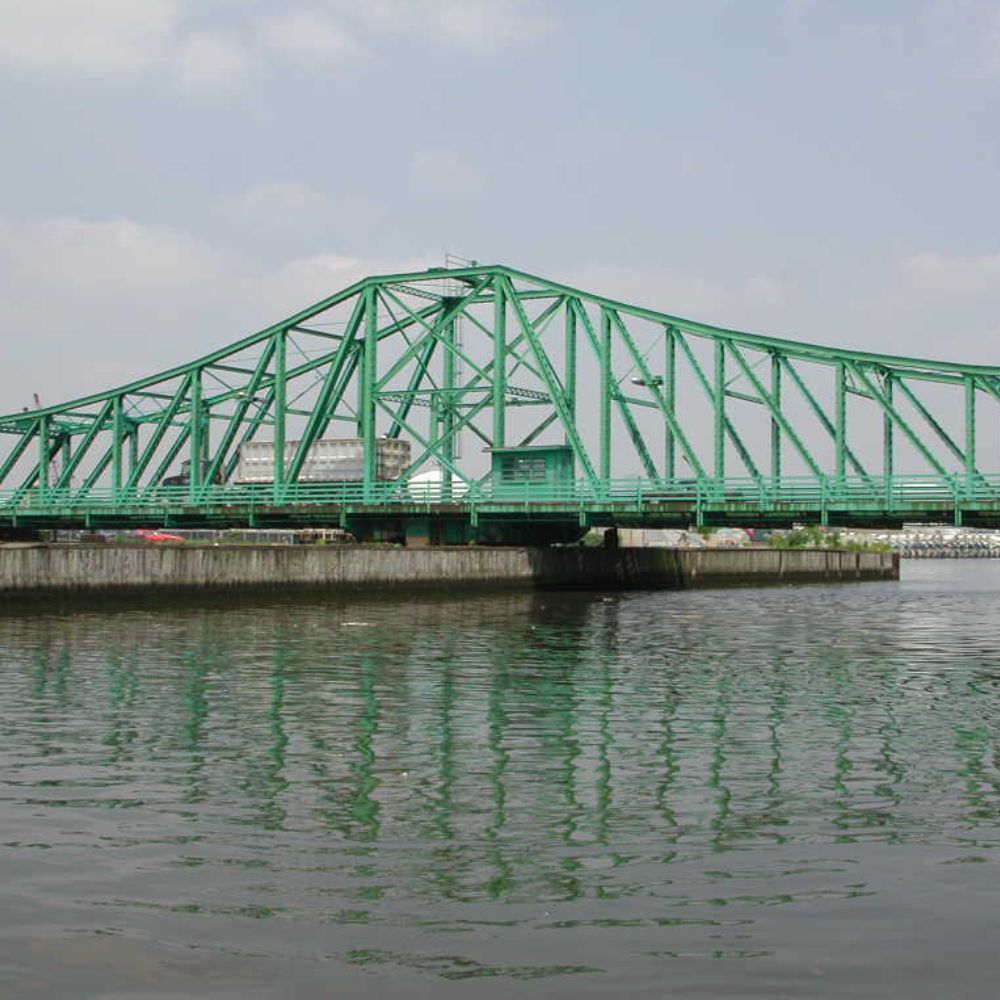 A green swing bridge just above the Newtown Creek in New York City.