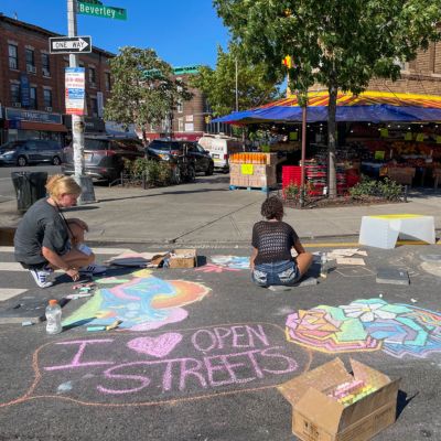 An Open Street decorated with chalk drawings. One of the drawings says “I Heart Open Streets”