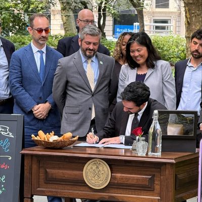 Mayor Mamdani holds up a recently signed bill alongside Councilmember Restler.