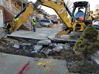 Repair truck repairing sidewalk