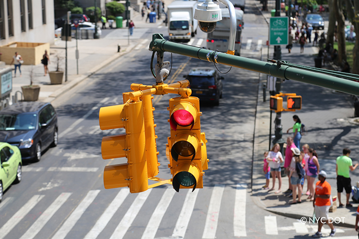 Aerial view of a traffic signal in New York City. The signal glows red.