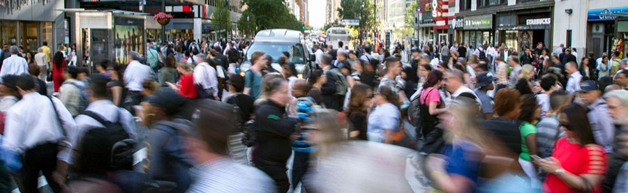 Large number of pedestrians cross a street in Midtown Manhattan