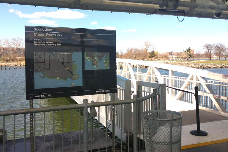 A walkNYC sign is posted near a ferry landing