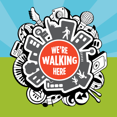 We're Walking Here logo with a round illustration featuring people walking through a city with musical instruments behind the skyline.