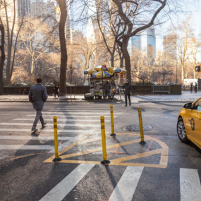 Yellow flexible delineators calm left turns by marking extra space between two crosswalks.