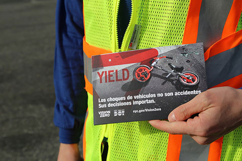 Street Team member hold postcard written in Spanish