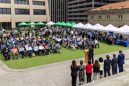 A crowd of people listen to Commissioner Rodriguez speak at the Doing Business with N Y C D O T Event.