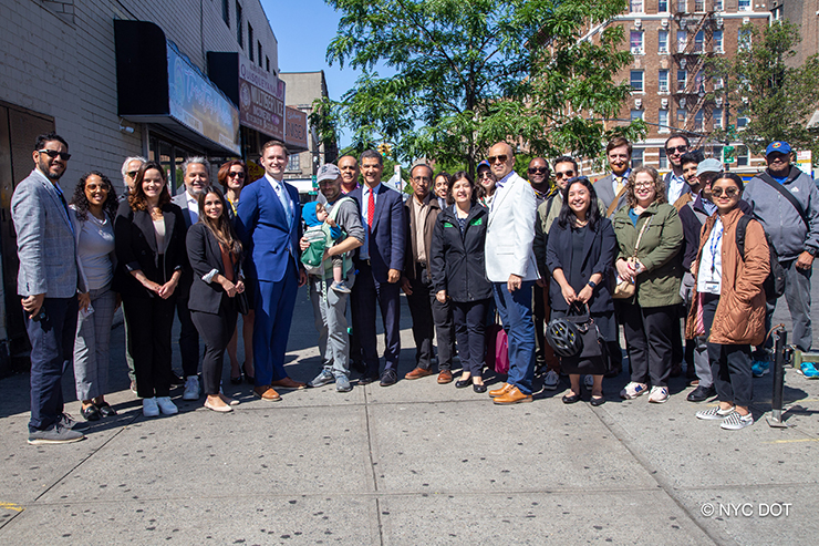 A group of people, including N Y C D O T Commissioner Ydanis Rodriguez and Manhattan Borough Commissioner Ed Pincar, smile at the camera during a tour of Upper Manhattan.