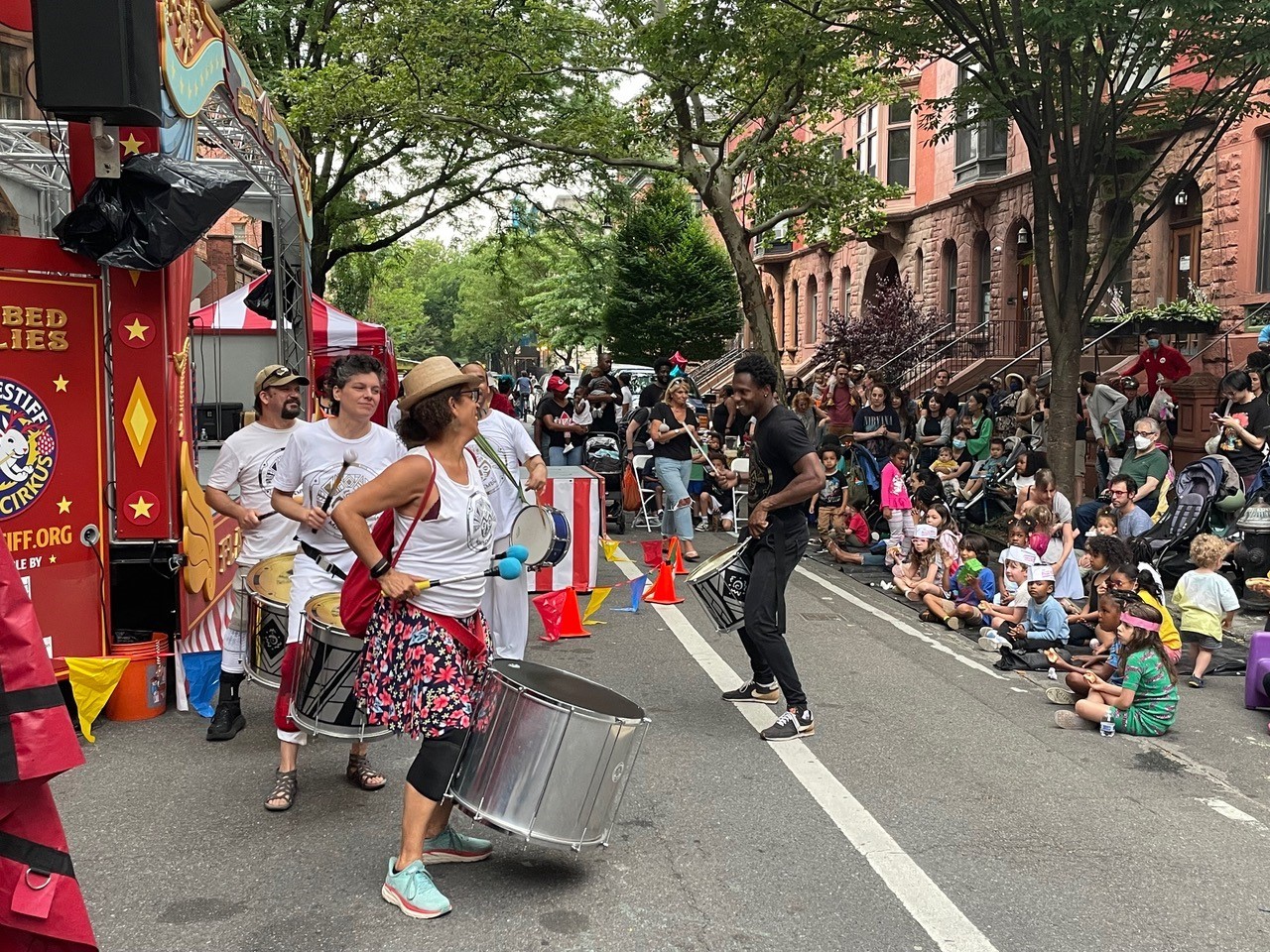 Drummers perform on a street closed to vehicle traffic
