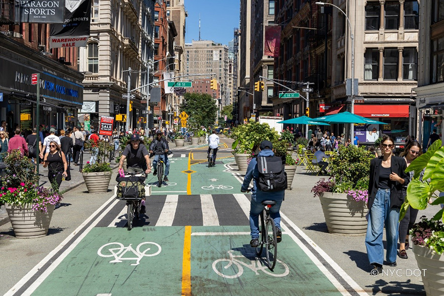 Cyclists and pedestrians travel along the newly redesigned plaza block on Broadway, from East 17th Street to East 18th Street.