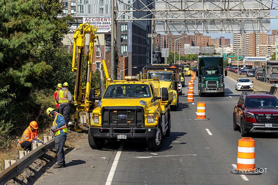 Бригада NYCDOT работает на оживленной дороге.