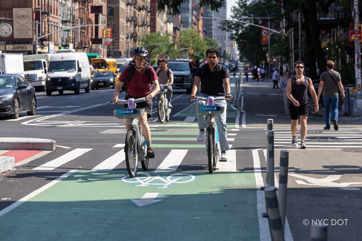 Cyclists and pedestrians travel on the recently expanded protected bike lane and ‘super sidewalk’ on Ninth Avenue in Manhattan. Credit: NYC DOT