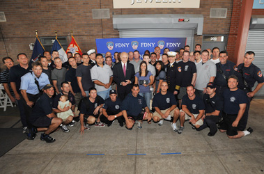 Linda Graffagnino (center) holds her husband's lieutenant's badge. She is surrounded by Fire Commissioner Nicholas Scoppetta, Chief of Department Salvatore Cassano and members of her husband's company, Ladder 5.