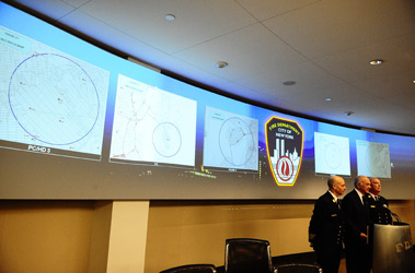 Commissioner Scoppetta, Chief Cassano and Chief McNally stand in front of five maps, outlining the areas each firehouse serves and their neighboring companies.