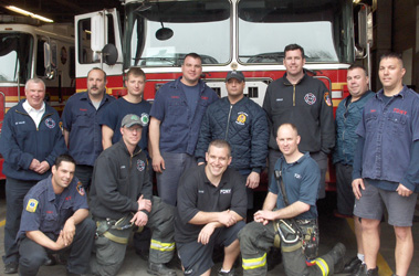 Firefighters Patrick Mataraza and Jay Prete with members from Engine 75 and Ladder 33 in front of their rigs.