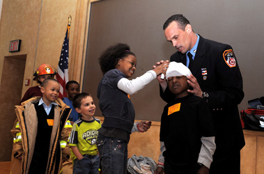 EMT Joe Fortis teaches children of FDNY staff members how EMS members treat injured patients. 