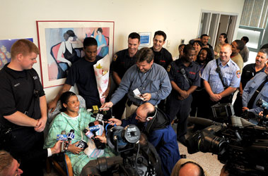 Fancy Powell, holding her newborn Jasai, and Daquan Webb, are surrounded by the FDNY members who delivered her baby in Harlem. (L to R in uniform) EMT Andrew Huyett, FF Edwin Dowling, FF Chris Schickler, FF Jermaine Martin, Lt. Brian Larkin and FF William Vanname.