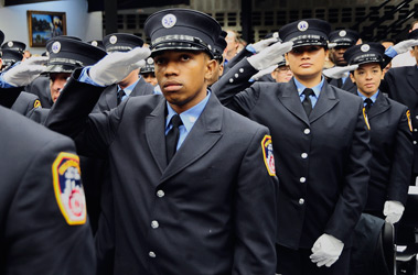 The 75 new EMTs salute during their graduation ceremony.