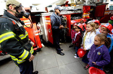Firefighters show their gear to first graders from the Brooklyn Friends School.