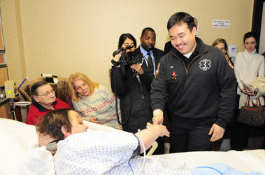 EMT Jack Lin meets Elmhurst Hospital Police Officer Nicholas Esposito on Dec. 24, as his mother, Antoinette, and wife, Carol, look on (far left). The off-duty EMT revived the Police Officer after he went into cardiac arrest near Elmhurst Hospital on Dec. 18.