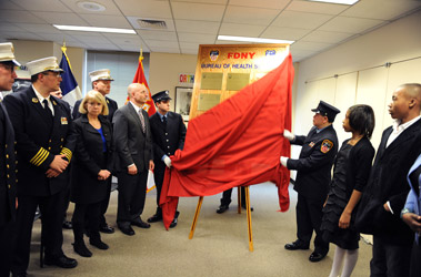 A plaque, including the names of four members of the Bureau of Health Services, is unveiled at FDNY Headquarters. (L to R) Reverend Stephen Harding, Chief of EMS John Peruggia, Dr. Kerry Kelly, Chief of Operations Robert Sweeney, Fire Commissioner Salvatore Cassano, ceremonial members, Amanda O'Brien and Wendell O'Brien, Jr.