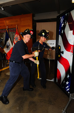 Firefighters demonstrate the forcible entry simulator.