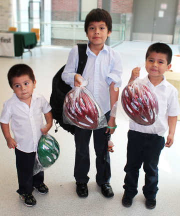 Brothers Jesus, Carlos and Cesar Rendon picked up brand new bicycle helmets in Bellevue Hospital's Pediatric Clinic as part of Children of Bellevue's 7th annual event promoting bicycle safety for children.