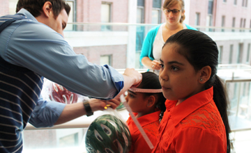 Sisters Ashley and Lesley Gonzalez receiving their bike safety helmets at Bellevue Hospital Center.