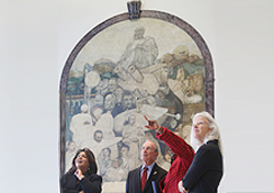 Mayor Bloomberg, Senior VP Jimenez-Hernandez and Deputy Mayor Gibbs in front of the mural 'Modern Medicine' (1940) by Charles Alston, as Exec. Dir. Soares points to another mural.