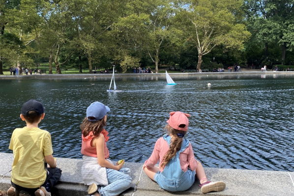 Children watching model boats in a park