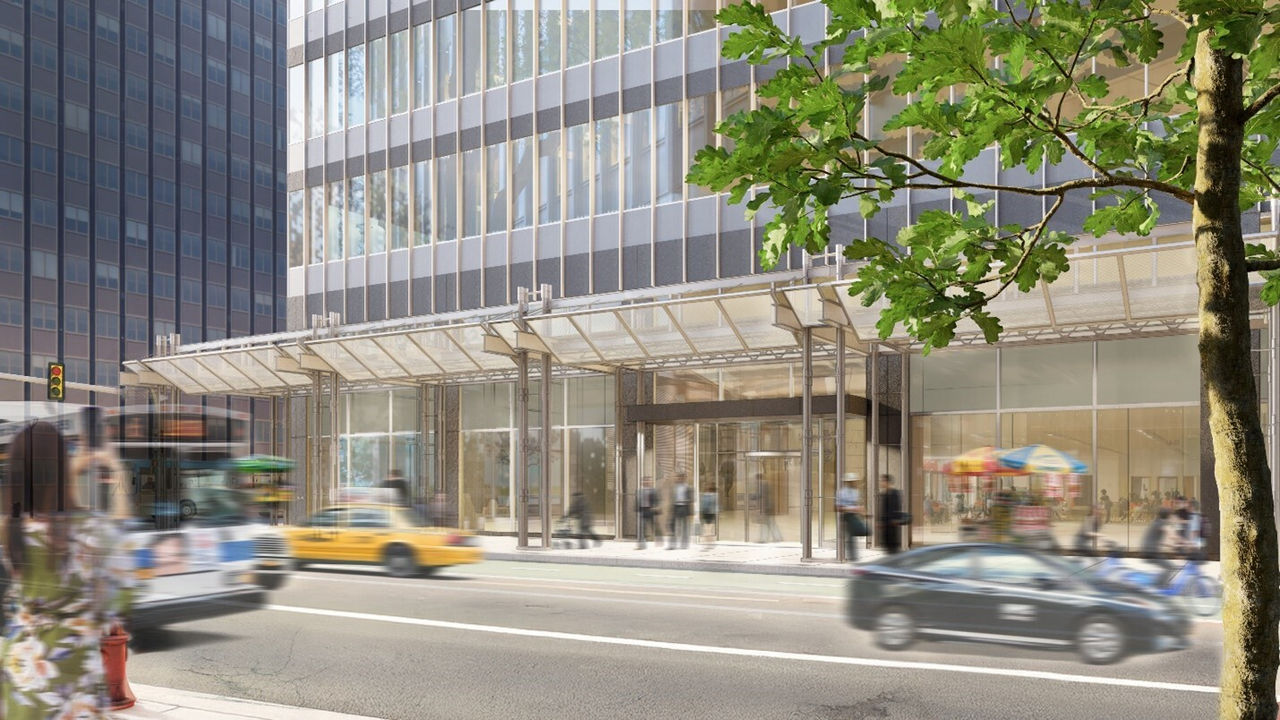 a luxury building with glass scaffold on its sidewalk, while cars moving on road.