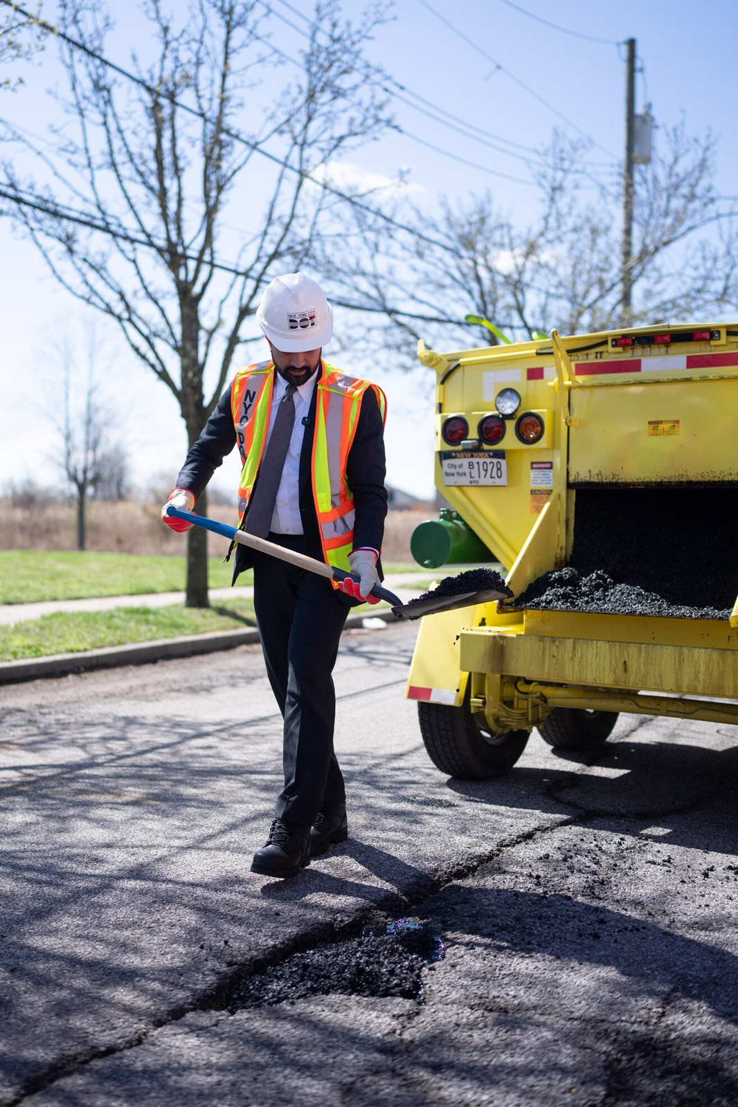 Mayor Mamdani holds a shovel of asphal