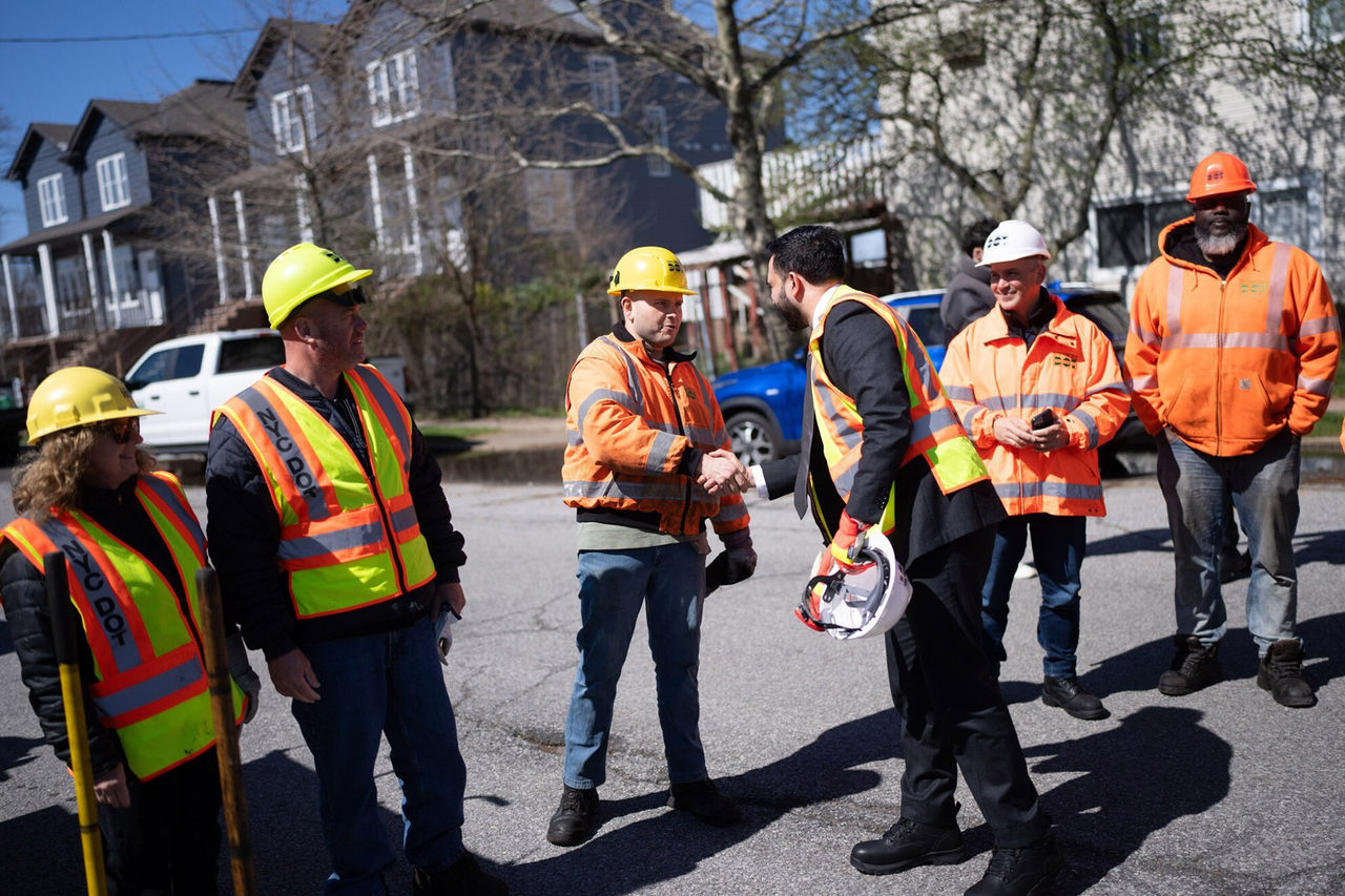 Mayor Mamdani shake hand with a construction worker, while a greeted a group of contruction worker