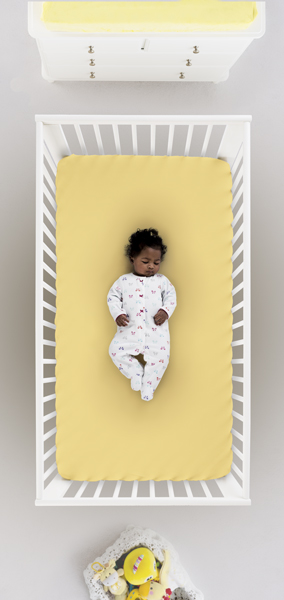 baby laying in crib, sleeping safely