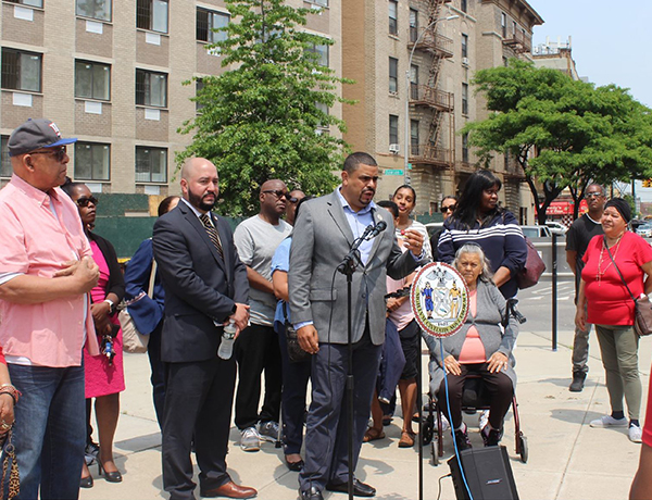 Bronx community board 2 district manager standing in front of people on sidewalk
                                           