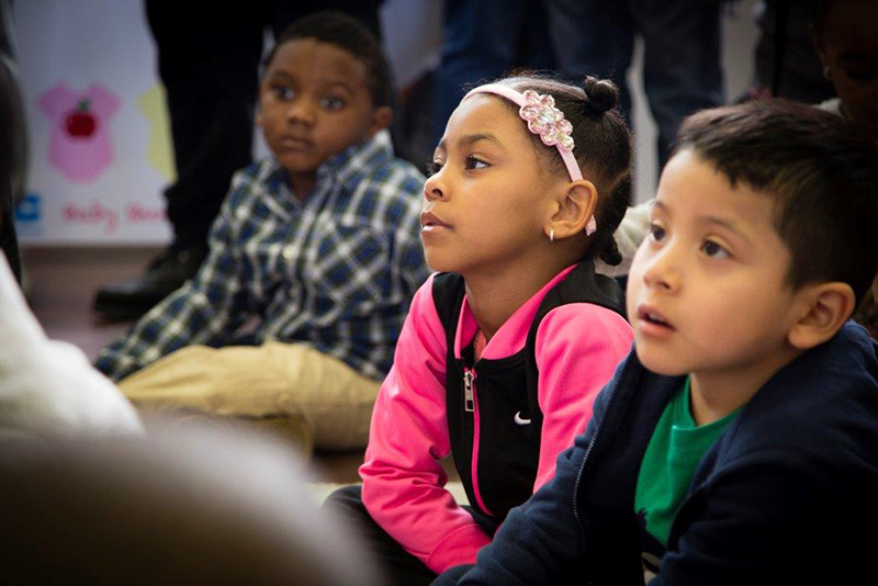 Three young children sitting and listening at an NYC Baby Shower event
