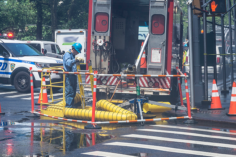 Emergency Con Ed worker conducting inspection at a street corner in Manhattan
                                           