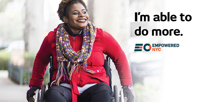 A smiling black woman in a wheelchair rolls down a public sidewalk. Headline text is, I’m able to do more. EmpoweredNYC logo is below text.