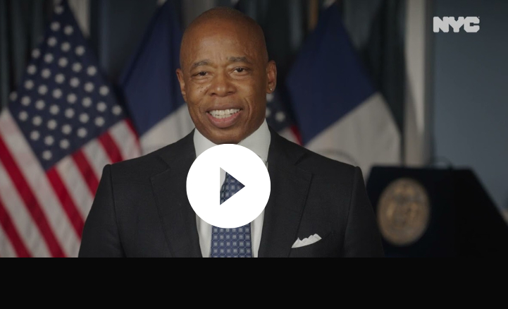 A screenshot of a video with Mayor Adams smiling as he makes an announcement. 
                                           