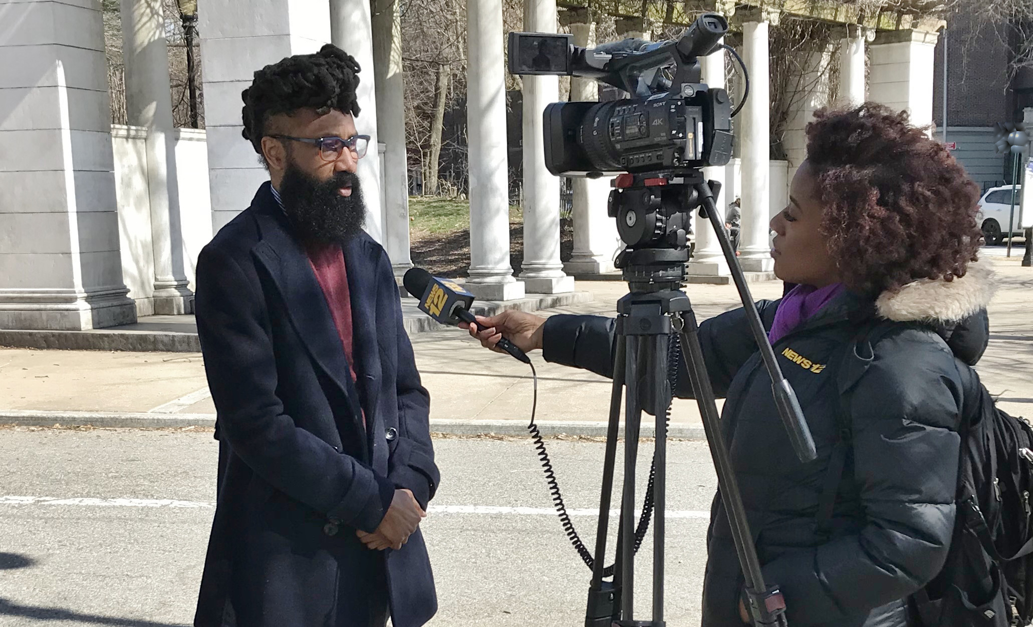 A TV cameraperson interviews Percent for Art director Kendal Henry in a park
                                           
