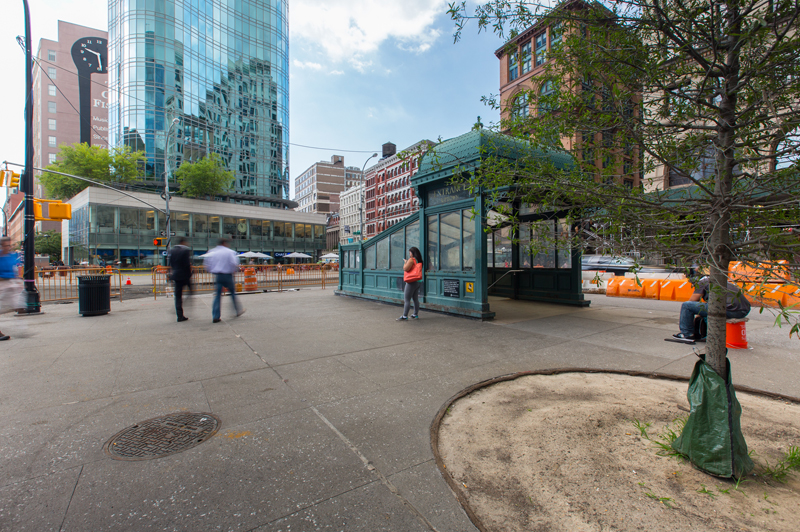 A woman walks past the subway entrance in Astor Place.