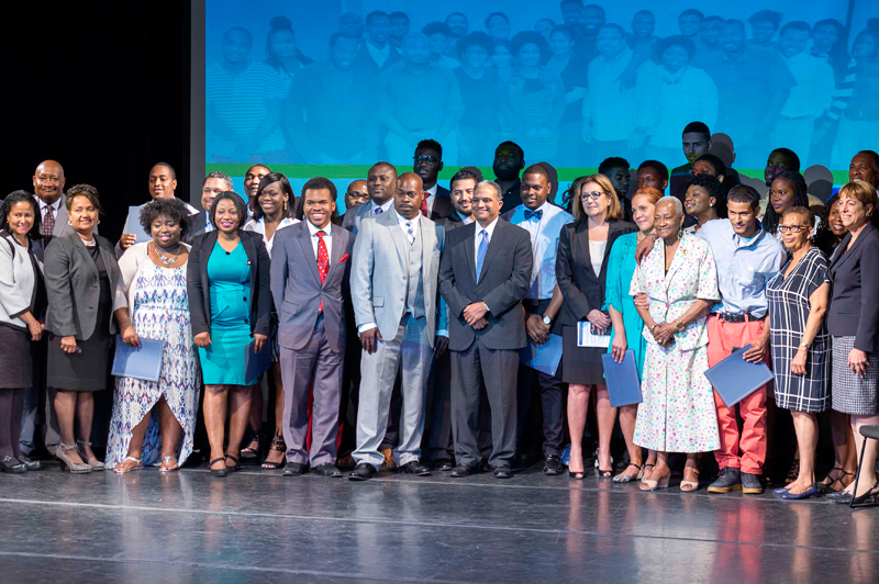Graduates of Opportunity Academy gather on stage for a photograph.