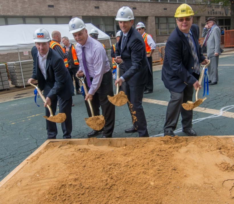 Four employees from DDC, DOT and Yeshiva University performing the ceromonial groundbreaking