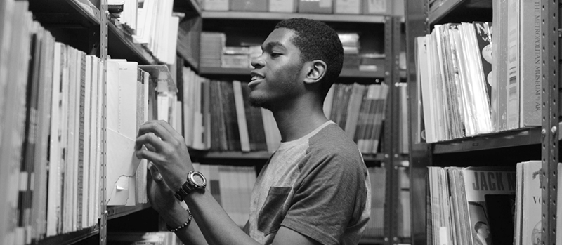 young man organizing books in a library