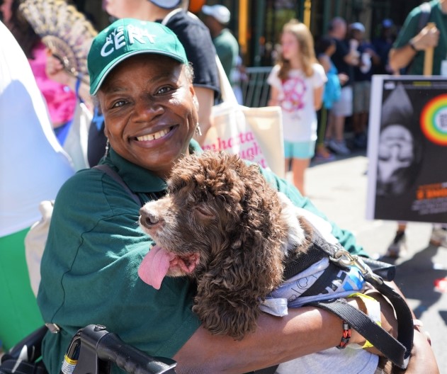 A woman in a wheelchair holds a service dog