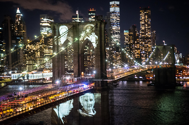 Brooklyn Bridge at night with photos projected on it