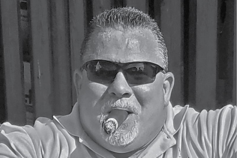 Det. Matt Hickey wearing sunglasses and smoking a cigar